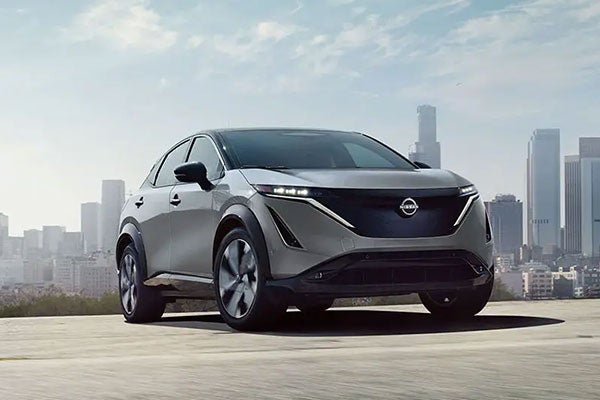 Side view of Nissan ARIYA in front of a building