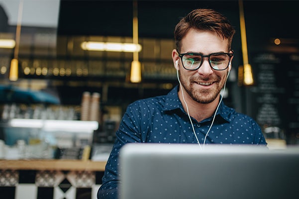 image of a man smiling at a laptop screen